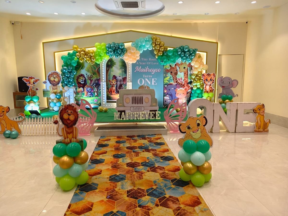 Jungle safari theme first birthday decoration with green gold balloons and animal cutouts