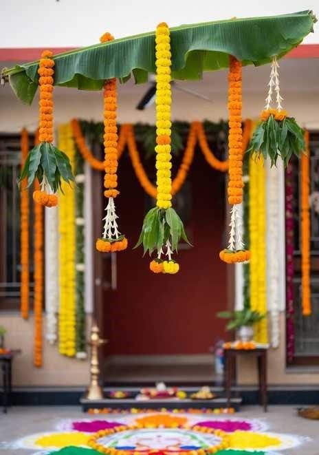Griha Pravesh entrance decoration with marigold garlands, banana leaf and rangoli
