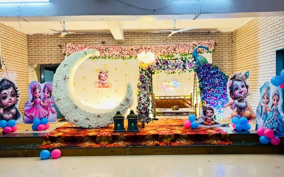 Krishna theme naming ceremony stage decoration with floral moon and swing setup